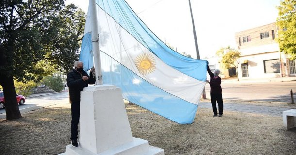 Dos jubilados izan todos los días la bandera en la placita del barrio